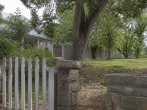 Older property with mature trees, fencing, and historic boundary features in Madison, AL, relevant to a metes and bounds survey.
